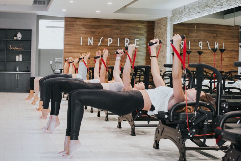 Person performing a Lagree Fitness exercise on a Megaformer, showcasing strength and endurance.