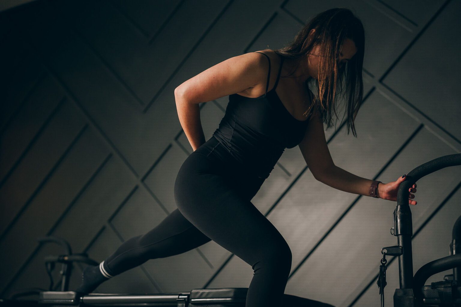 Lagree vs. Pilates - Inspire Seattle An Inspire Seattle client performing a controlled exercise on studio equipment